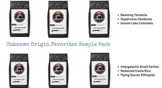 Six black coffee bags arranged in two rows on a white background, with text listing coffee varieties: Beaming Tanzania, Hypernova Honduras, Groom Lake Colombia, Intergalactic Brazil Santos, Redacted Costa Rica, and Flying Saucer Ethiopia. Large text reads 'Unknown Origin Favorites Sample Pack.